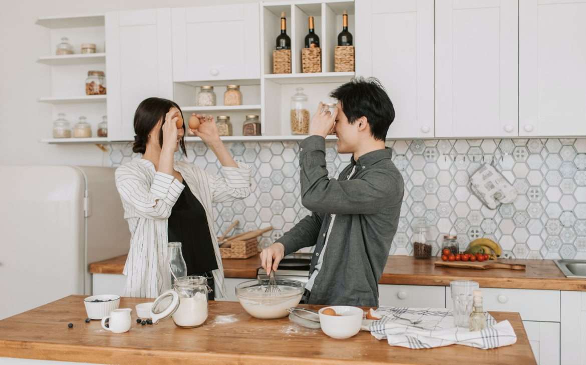 a couple preparing food in a kitchen