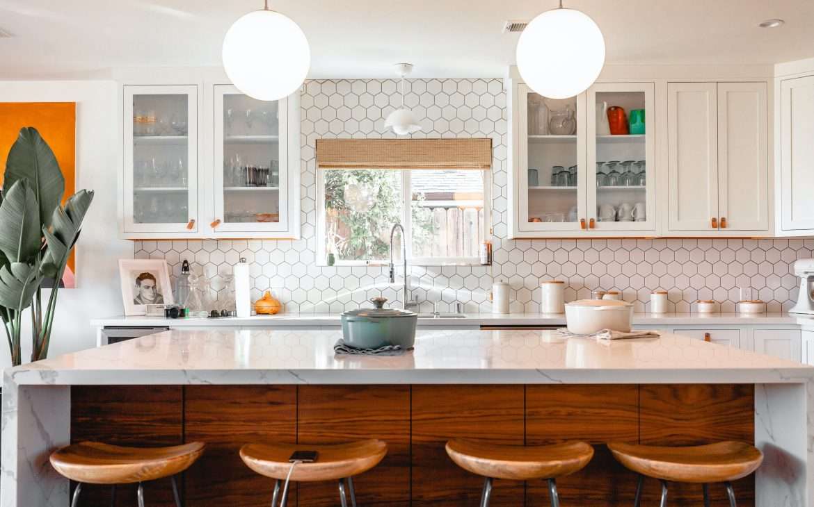 a modern kitchen with four brown stools
