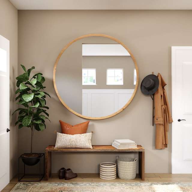 a wall with mirror and coat hanger near a storage bench